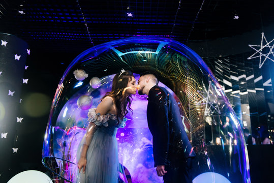 The bride and groom kissing inside the balloon. Bubble show at the wedding