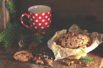Christmas and New Year composition with delicious chocolate cookies, peanuts and cup of coffee or tea