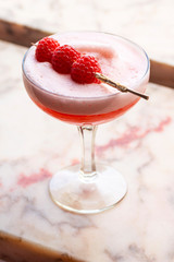 Pink Clover Club Cocktail, a Gin and Raspberry Based Drink With a Layer of Egg White Foam in a...