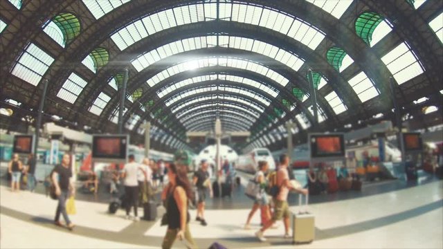Travelers with suitcase, baggage and backpack moving on the train station of Milan. Slow motion
