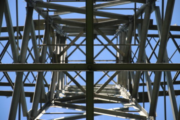 Power lines on a tower with blue sky and cirrus clouds in Rotterdam Nesselande as a symmetric view
