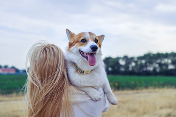 Girl walking with her dog pembroke welsh corg in nature