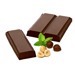 Broken chocolate blocks and cracked pieces with hazelnuts or filberts isolated on white background