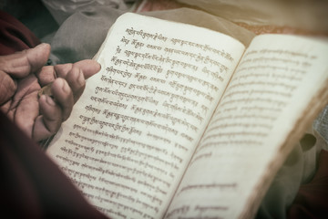 Man reading an old book. A book with text is shown in close-up.