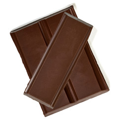 Broken dark chocolate bars from top view isolated on white background