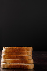 Toast bread on on wooden background. Low key. Vertical frame. Close-up