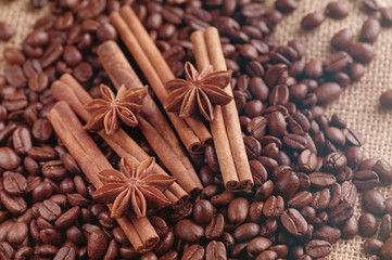 Obraz na płótnie Canvas Aromatic roasted coffee beans and anis or badian, sticks of natural cinnamon on background close up