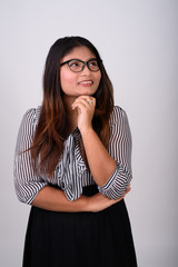 Studio shot of young happy fat Persian businesswoman smiling whi