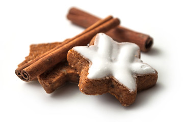 closeup of christmas biscuit shaped star with cinnamon stick on white background