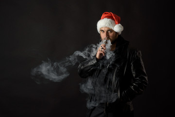 Man with beard in Santa red hat smoking electronic sigarette. vape pen. vape smoke. Christmas...