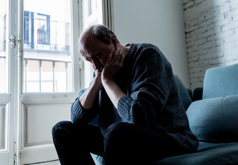 Fototapeta premium Depressed overwhelmed old man feeling exhausted alone and unhappy suffering from depression