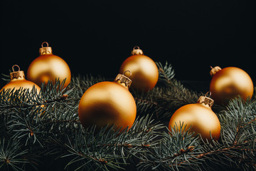 Christmas or New Year toy decorations golden balls and fur tree branch rustic on wooden background,...