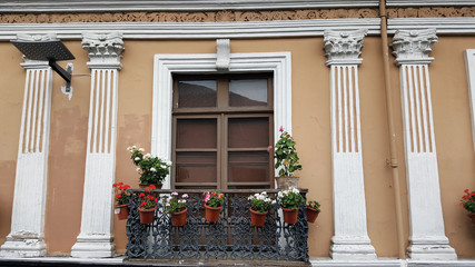Hanging pots of flowers from window in Quito, Ecuador.