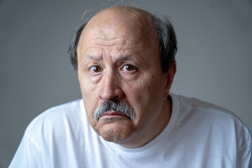 Close up portrait of sad old man face suffering from depression