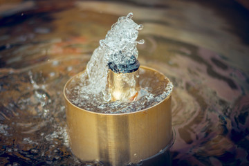 Sprinkler of a crafted fountain with water sprinkling out of it