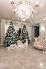 Christmas evening. classic luxurious apartments with decorated christmas tree. Living hall large mirror, chair, high windows, columns and stucco.