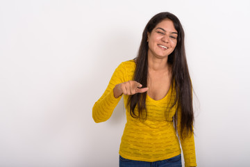 Studio shot of young happy Indian woman smiling while winking an