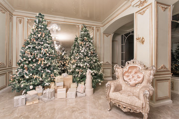 Christmas evening. classic luxurious apartments with decorated christmas tree. Living hall large mirror, chair, high windows, columns and stucco.