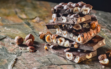 Chocolate tower with cocoa and nuts, chocolate culinary background. Handmade chocolate pieces with spices.