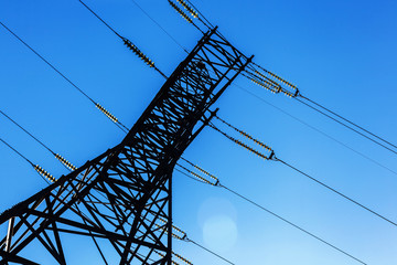 High voltage electricity pylon and transmission power line on the blue sky and white clouds on the...