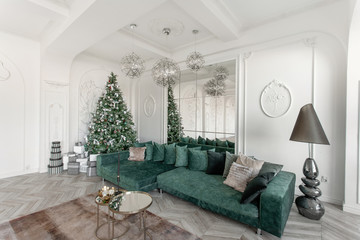 Fototapeta na wymiar Christmas morning. classic luxurious apartments with decorated christmas tree. Living hall large mirror, green sofa, high windows, columns and stucco.
