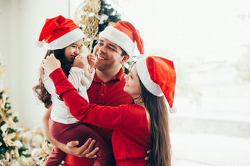 Young family celebrating Christmas at home.Happy young family enjoying their holiday time together.