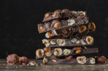 Chocolate tower with cocoa and nuts, chocolate culinary background. Handmade chocolate pieces with spices.