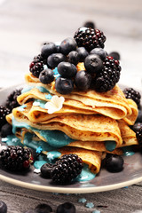 Delicious Tasty Homemade crepes or pancakes with blackberries,blueberries and blue spirulina nicecream.