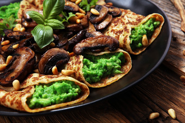 Savory Homemade Mushroom and Spinach Crepes with Cheese and avocado.
