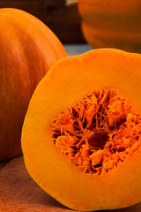 Slice of ripe pumpkin with fibers in the core and flesh orange.