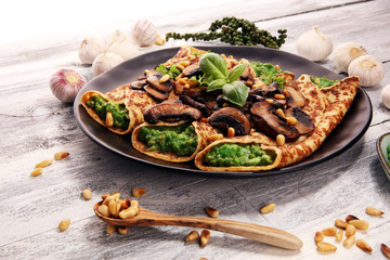 Savory Homemade Mushroom and Spinach Crepes with Cheese and avocado.