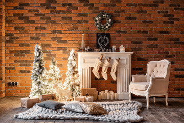 Loft apartments, brick wall with candles and Christmas tree wreath. White wool socks for Santa on the fireplace. Knitted carpet and chair, Christmas tree