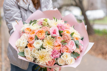 Beautiful spring bouquet in woman hand. Arrangement with various flowers. The concept of a flower shop. A set of photos for a site or catalogue. Work florist.