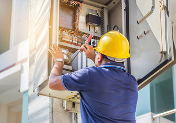 Electrician screwing equipment repairing in fuse circuit breaker box