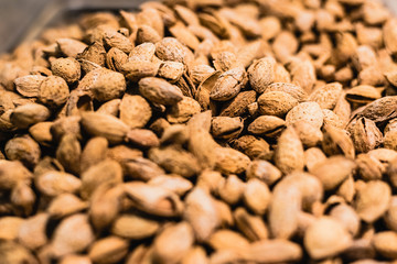 A pile of dried unpeeled almonds