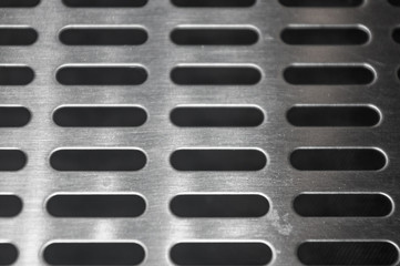 stainless steel grating with oblong holes, close-up