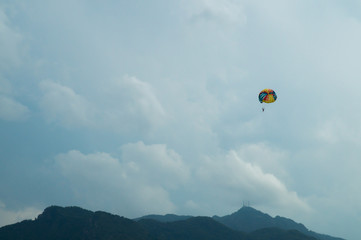 Skydiver flying with a colorful parachute on sky background