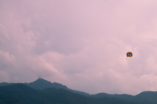 Skydiver flying with a colorful parachute on sky background