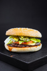 Homemade burger with grilled beef meatball, burger on a black backgroud, Craft beef burger, fresh tasty burger