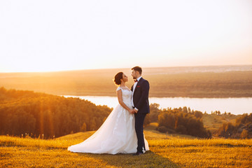 Newlyweds hold hands during a wedding ceremony outdoors
