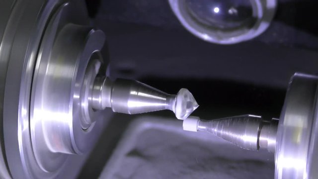 A diamond cemented on a dop spins against girdling stick