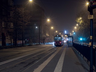 Naklejka na ściany i meble Night time tram stop waiting for passengers