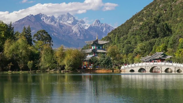 Jade Dragon Snow Mountain and the Suocui Bridge over the Black Dragon Pool in the Jade Spring Park, Lijiang, Yunnan province, China.