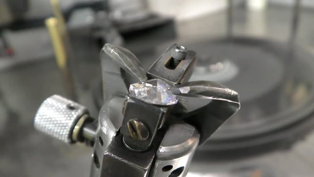 A diamond cemented on a dop is inspected