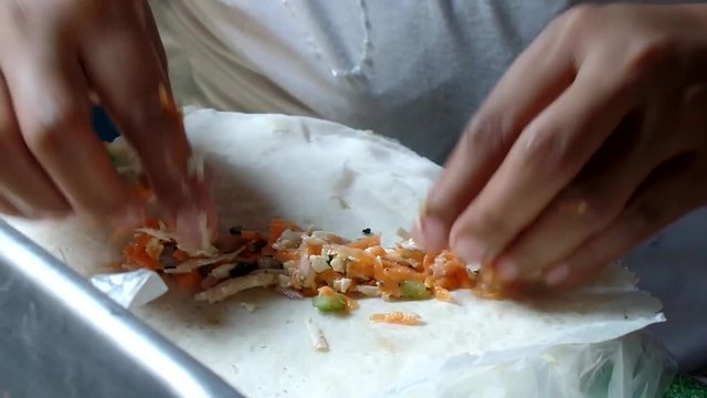 Wrapping up various vegetable lumpia rolls sorties in a dirty kitchen