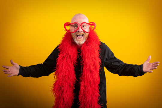 Portrait of man being funny with feather boa and heart shaped glasses