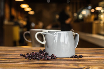 Obraz na płótnie Canvas Hot tea with berries, wood background, teapot with tea, cosiness