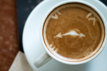 Closeup of A cup of Latte Art hot coffee over wooden  table top background in coffee's shop