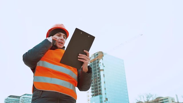 Engineering man Consulting People on construction site holding blueprint in his hand. Building inspector. Senior engineer Winter Jacket man in suit and helmet lifestyle outdoor. construction concept