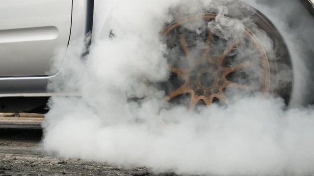 Drag car make tires warm up with smoke, Car racing burnout rubber off its tires in preparation for the race.
